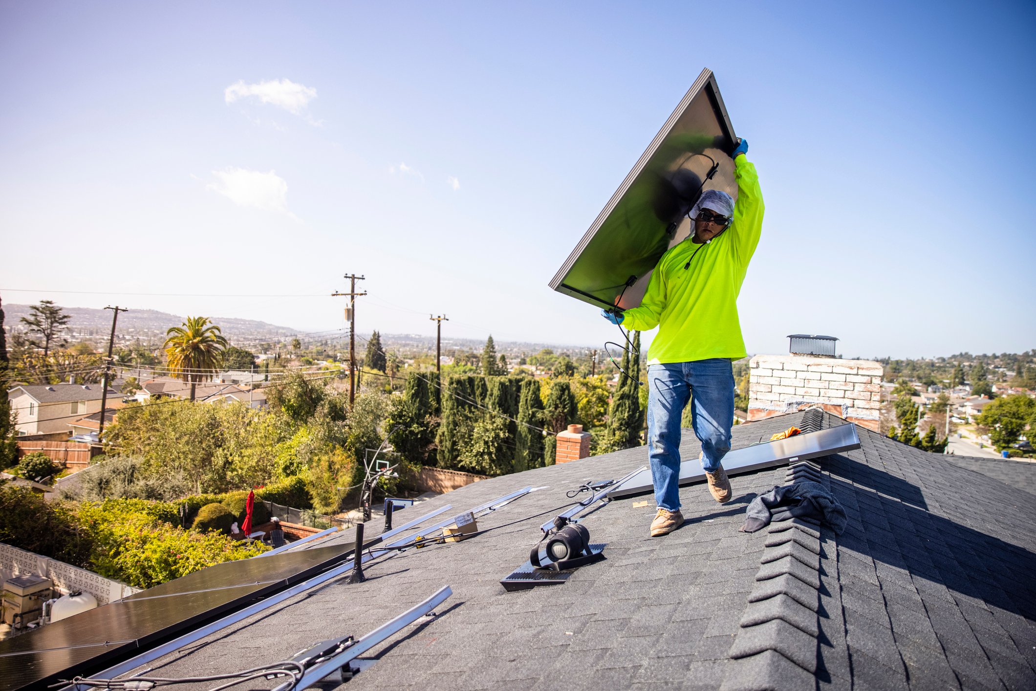 Worker carrying a solar panel.
