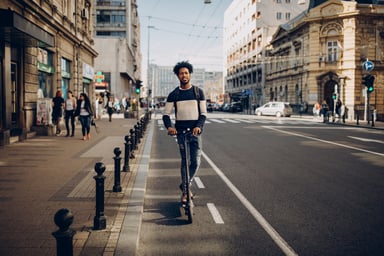 Person Riding Electric Scooter in City