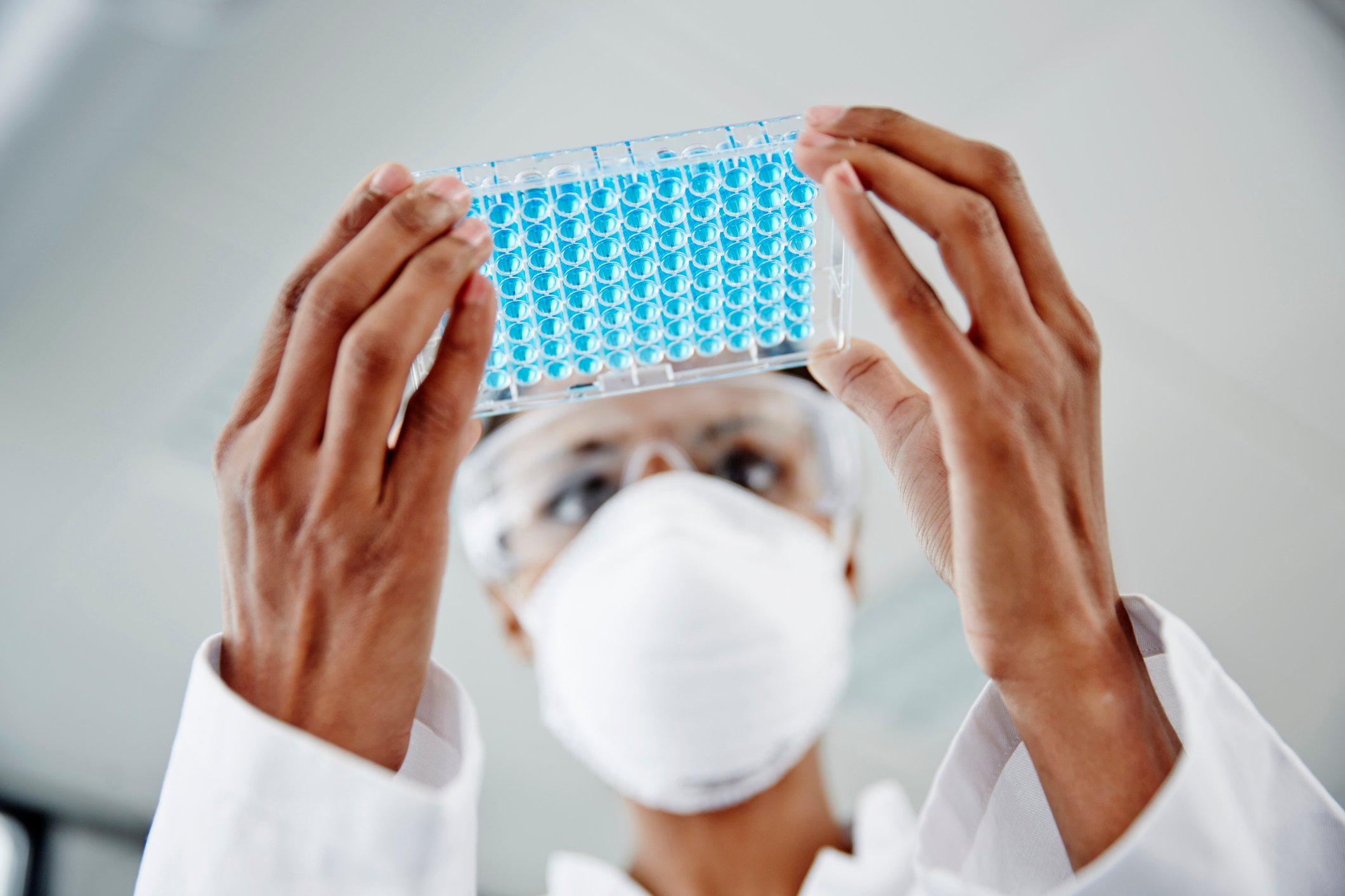 scientist-looking-at-well-plate