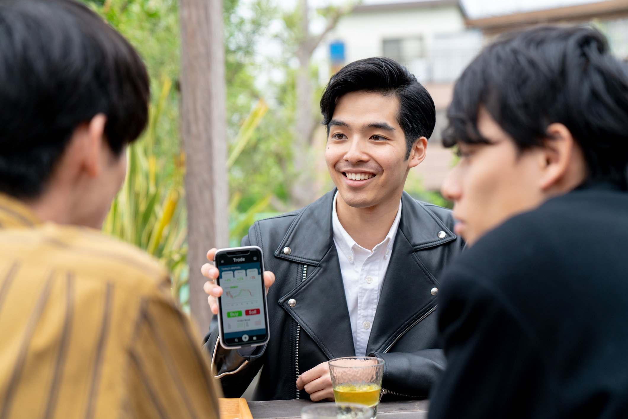 Young man explaining his investment to his friends.