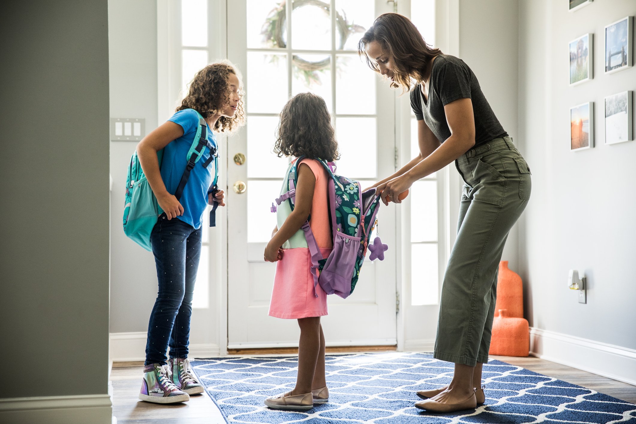 Mother packing daughter's backpack for school. 
