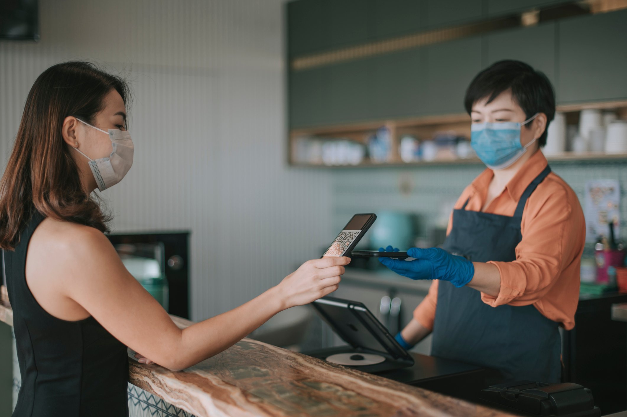 A customer uses a QR code on their smartphone to check out 