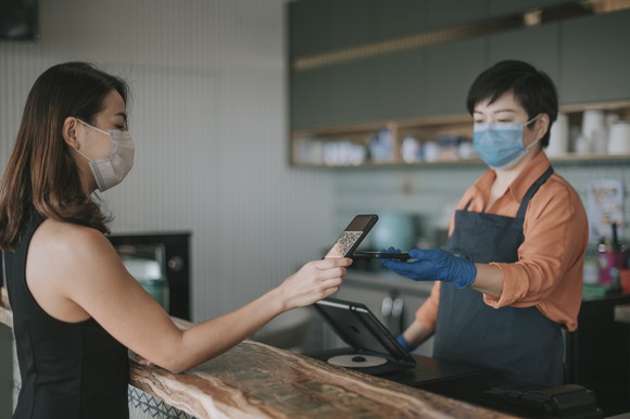 A customer uses a QR code on their smartphone to check out 