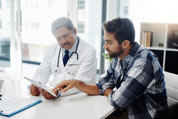 A young man meets with his doctor for an appointment.