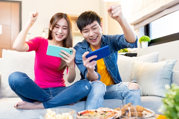 Two people play mobile games.