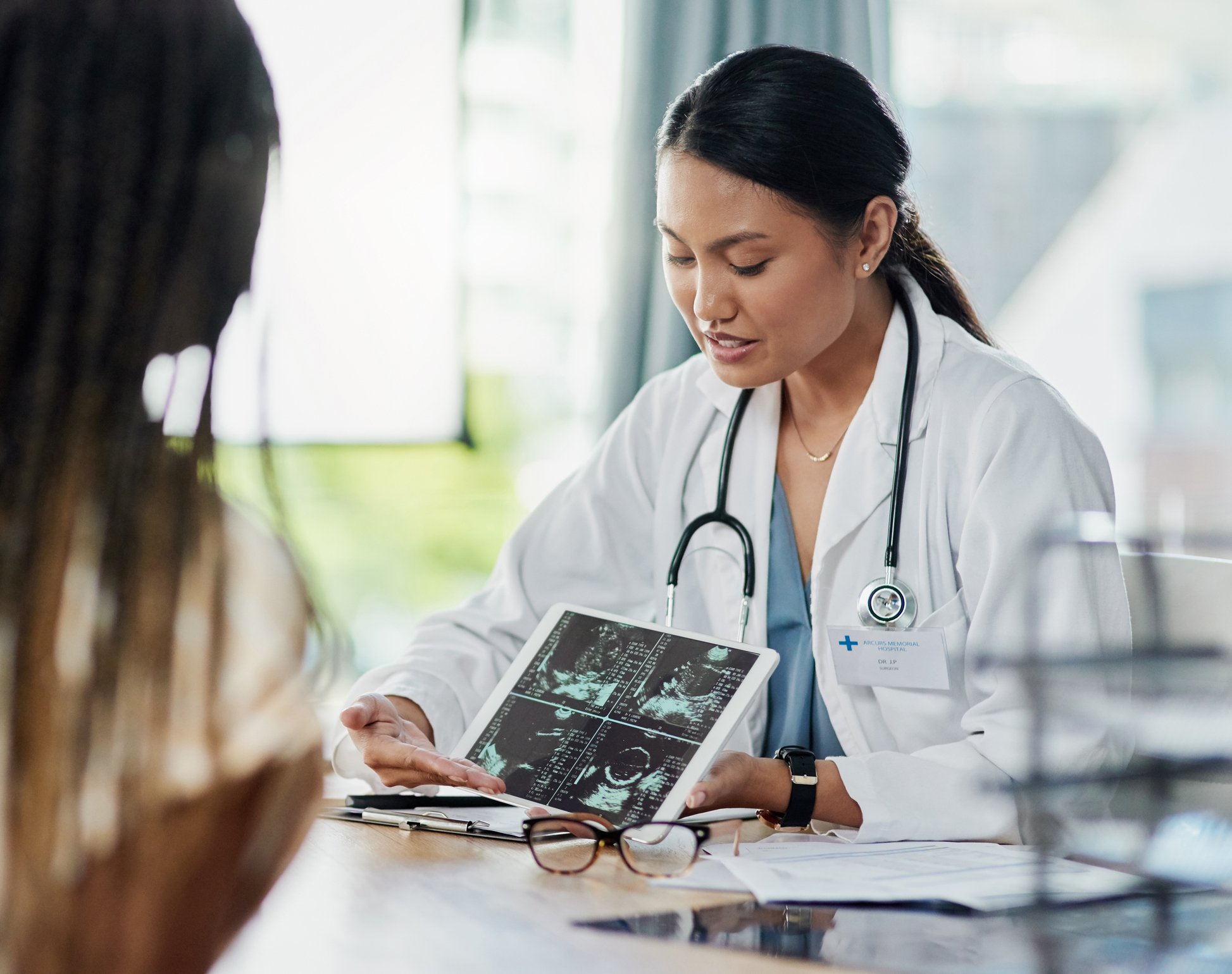 A doctor showing a patient something on a tablet. 