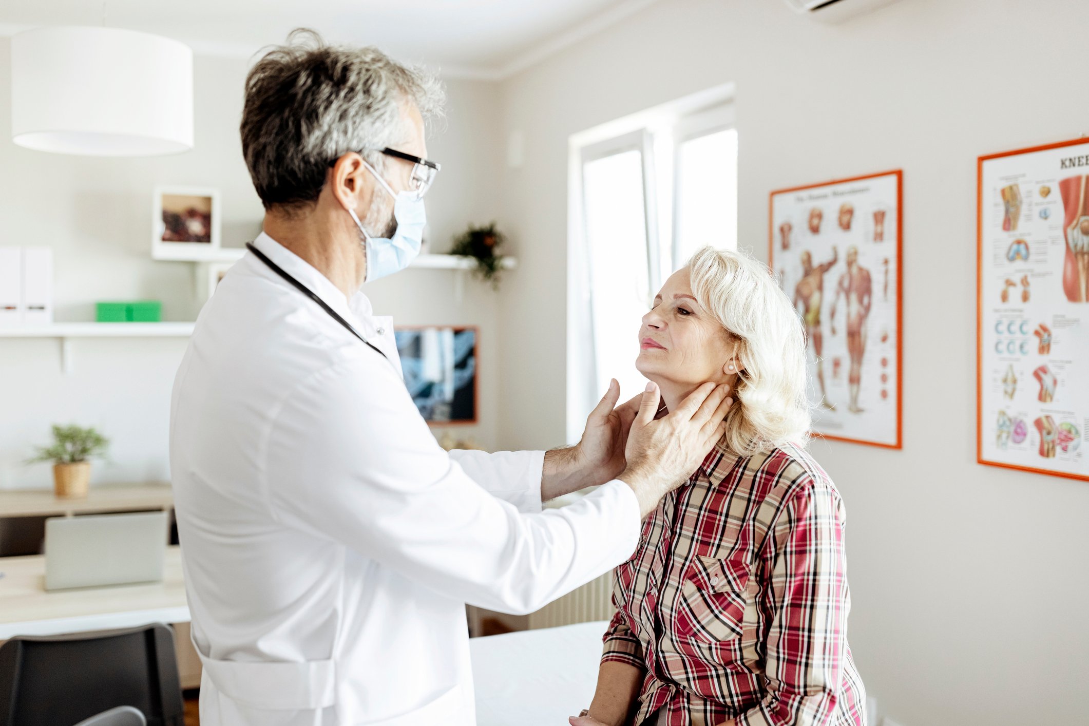 A doctor performs a physical exam on a senior patient.