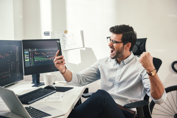 Investor excited while looking at computer screen.