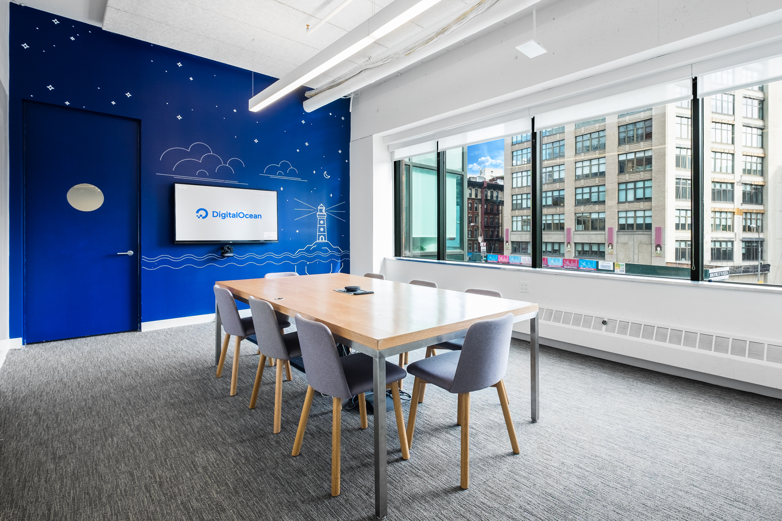 A monitor with the DigitalOcean logo in a room.