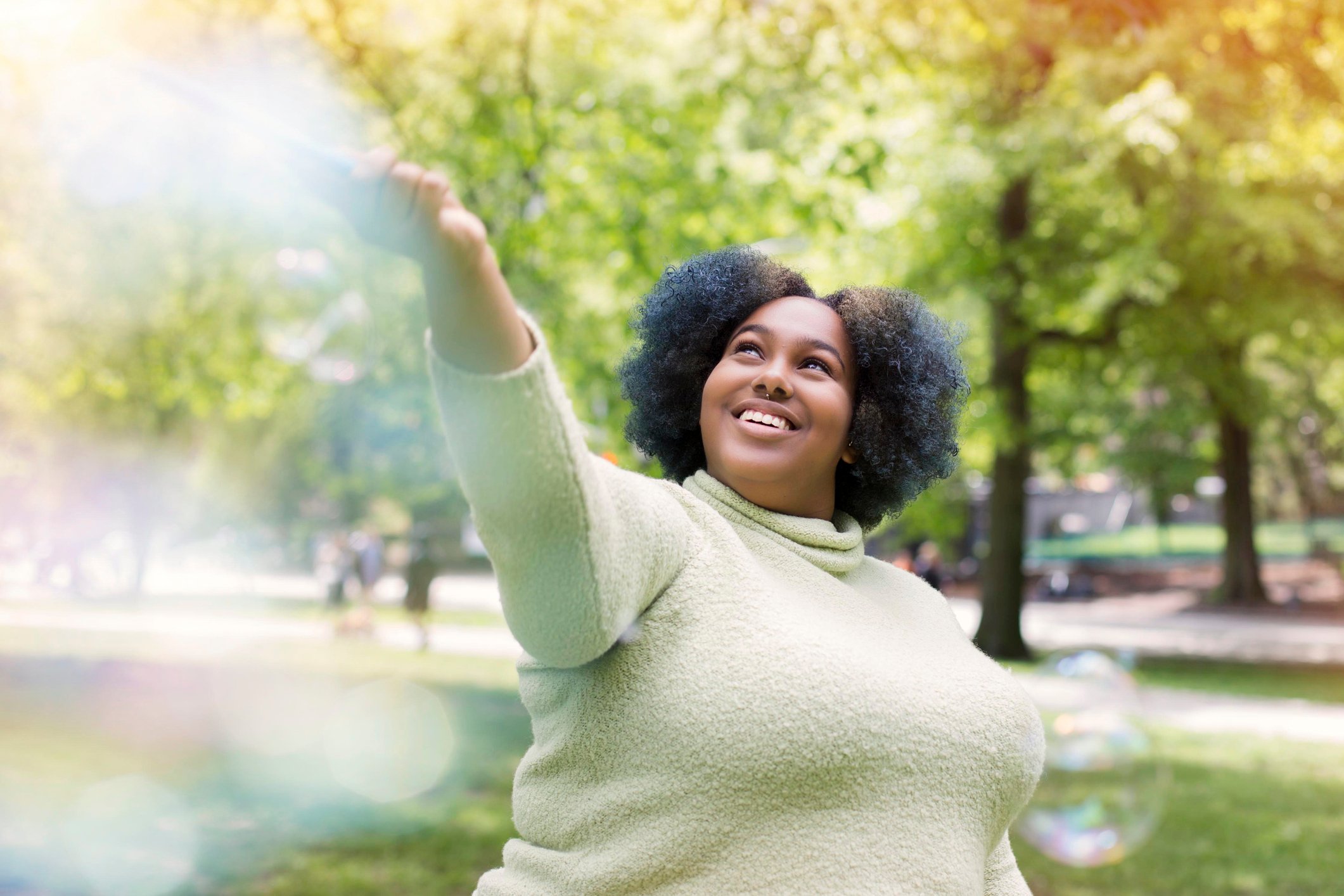 A woman stretching her hand out in a park