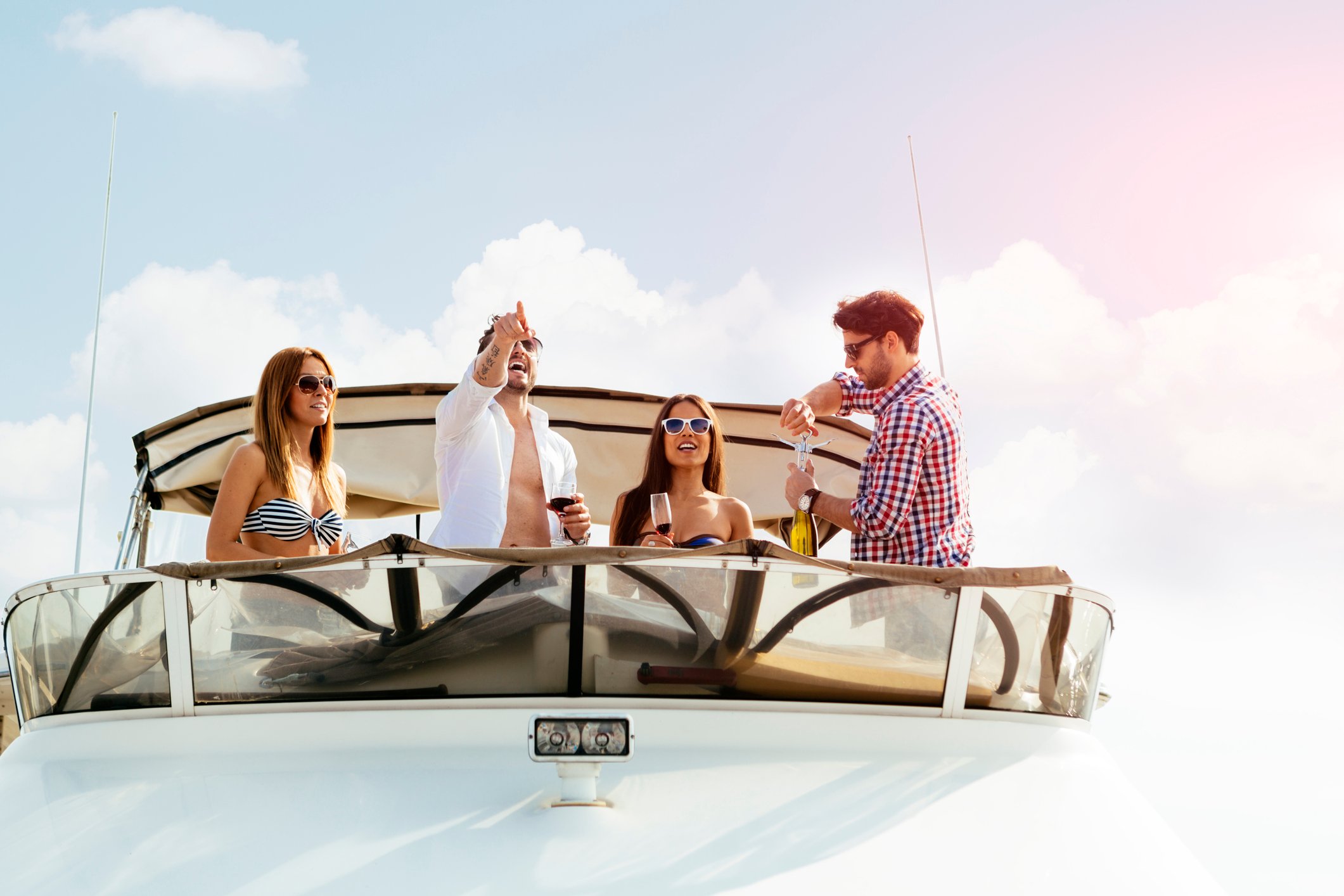 A group of young people enjoying themselves on the bow of a yacht.