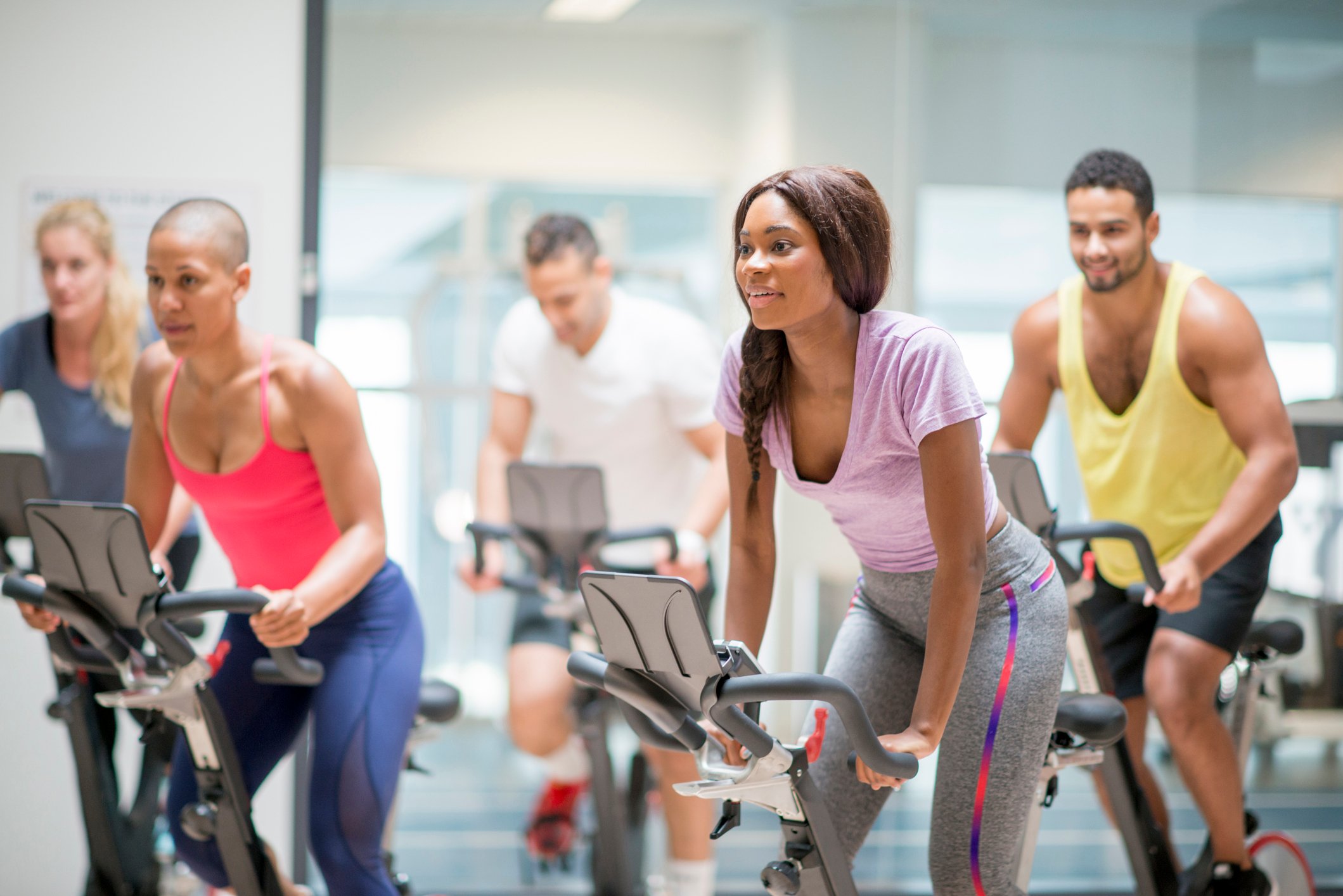 A group of people on exercise bikes.