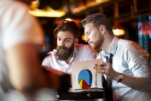 Investors evaluating growth charts and stock data.