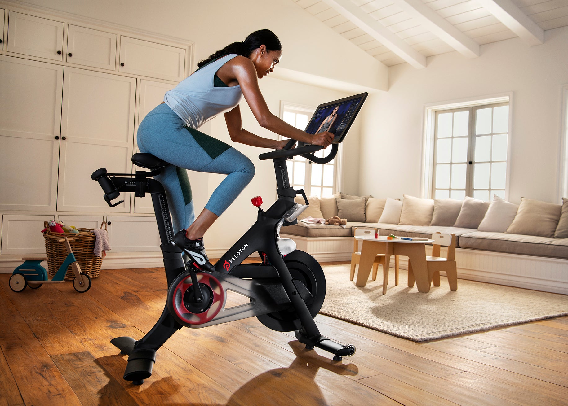 Person in workout gear riding a Peloton bike.