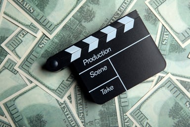 Movie clapper and hundred-dollar bills