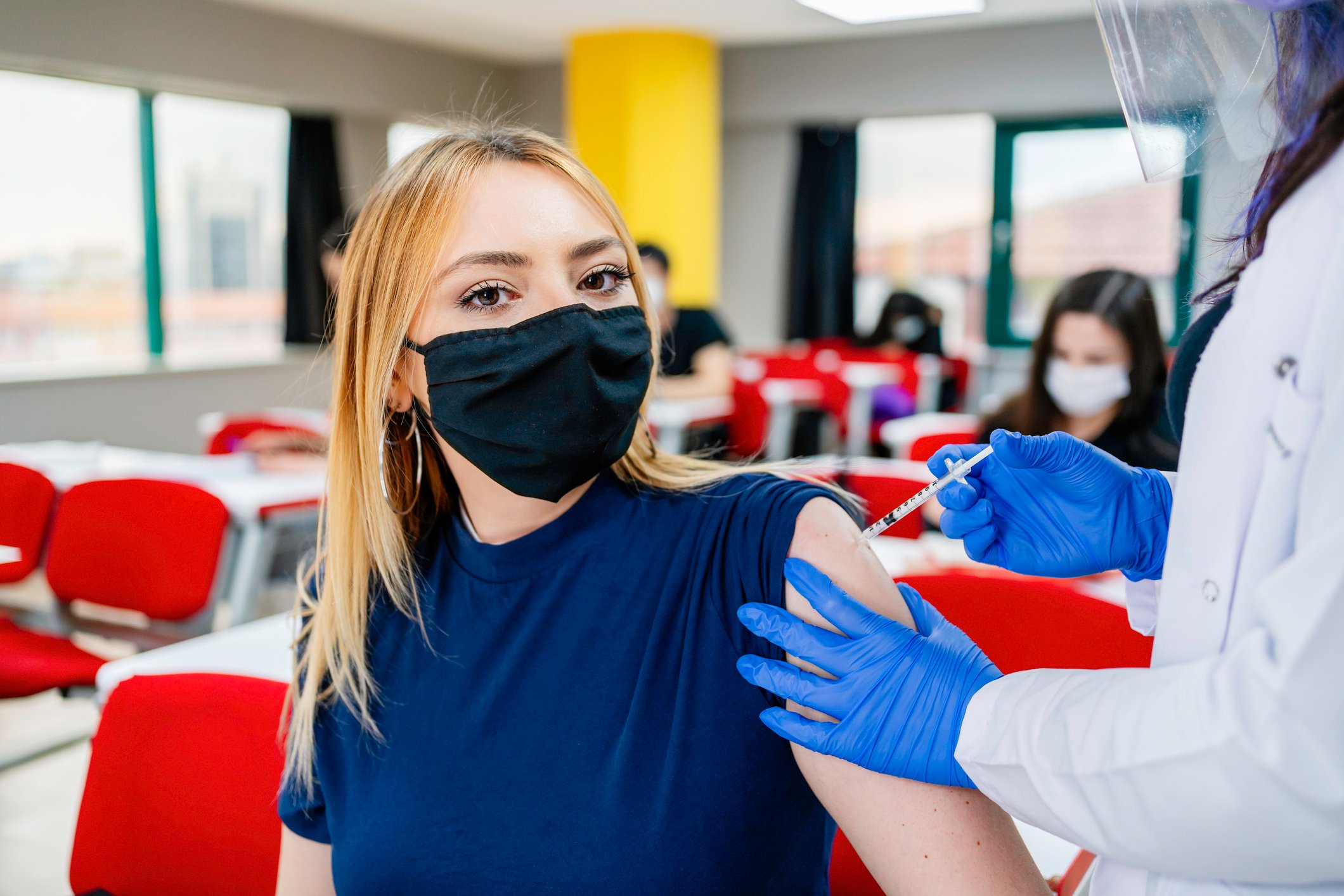 A healthcare professional is administering a vaccine to a patient. 