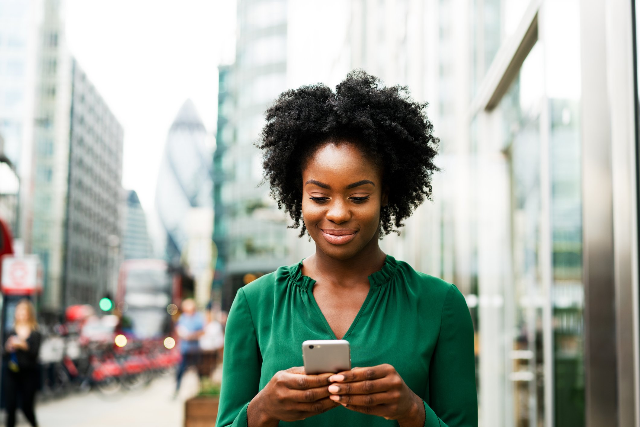 A person checks a smartphone on the street.