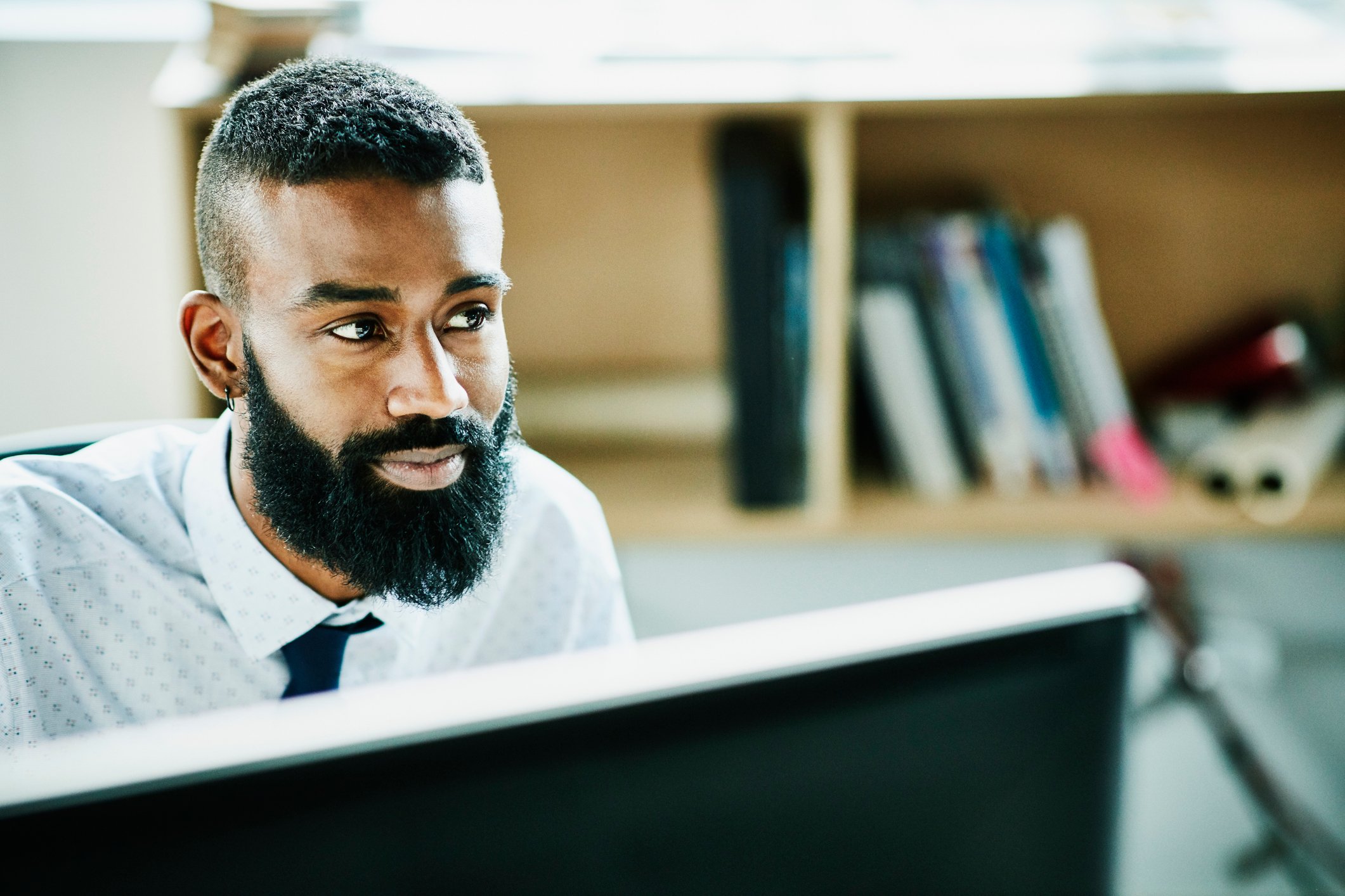 A businessperson sitting at their desk, smiling. 