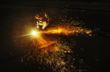 A person using a welder with sparks flying.