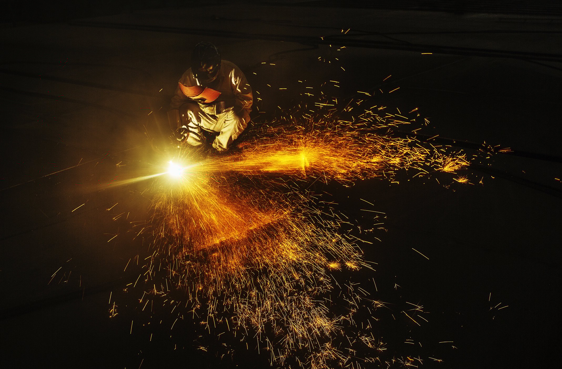 A person using a welder with sparks flying.