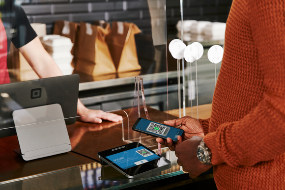 Person using Cash App to pay on Square reader. 