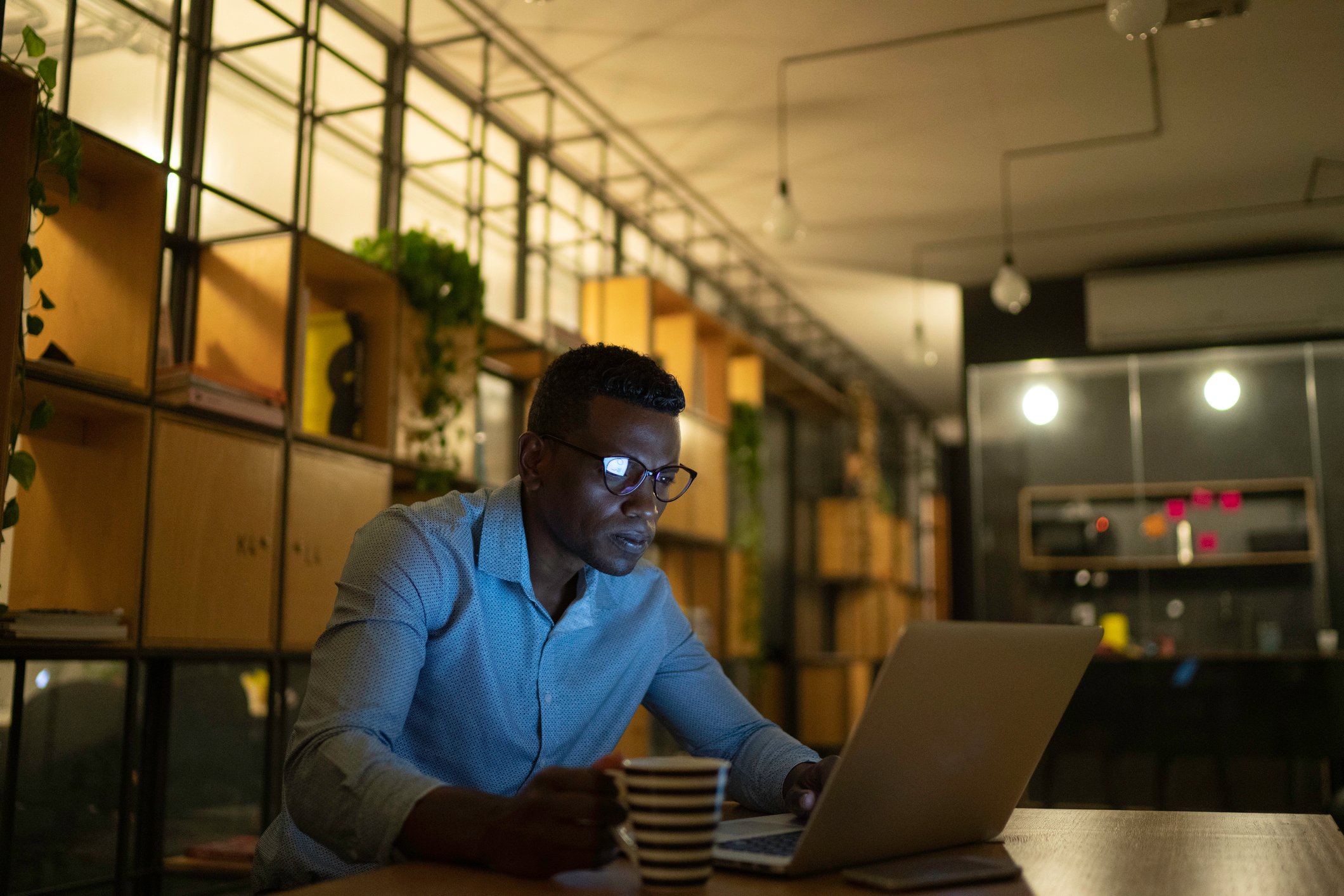 Person in an office looking intently at a laptop screen. 
