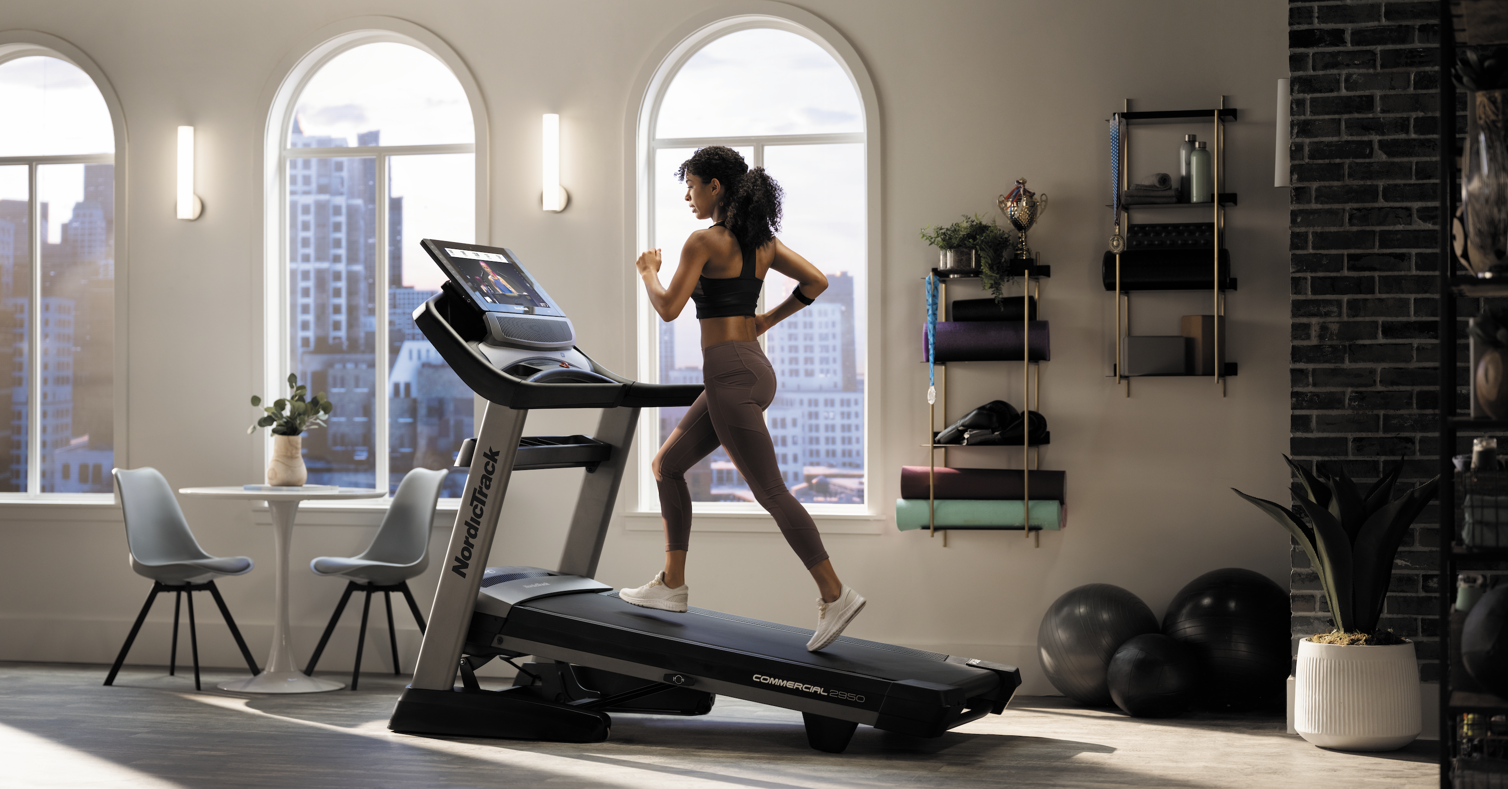 A NordicTrack user running on a treadmill in an apartment.