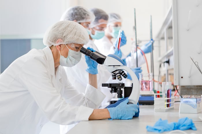 A scientist examining a specimen under a microscope.