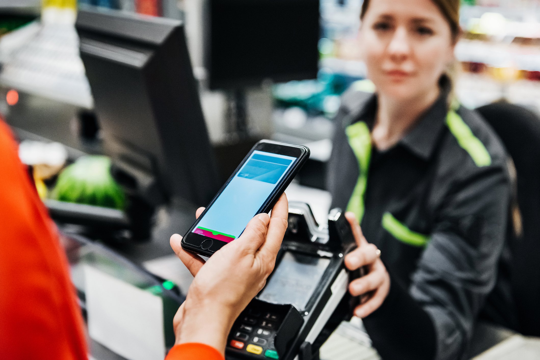 Person using smartphone to pay for items.