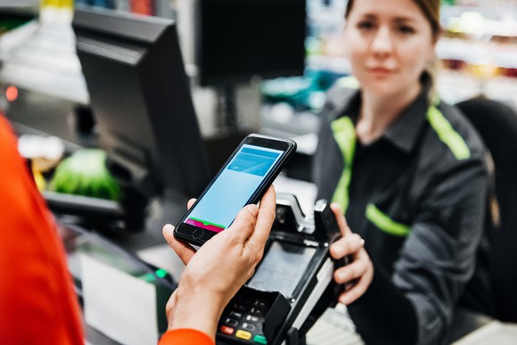 Person using smartphone to pay for items.