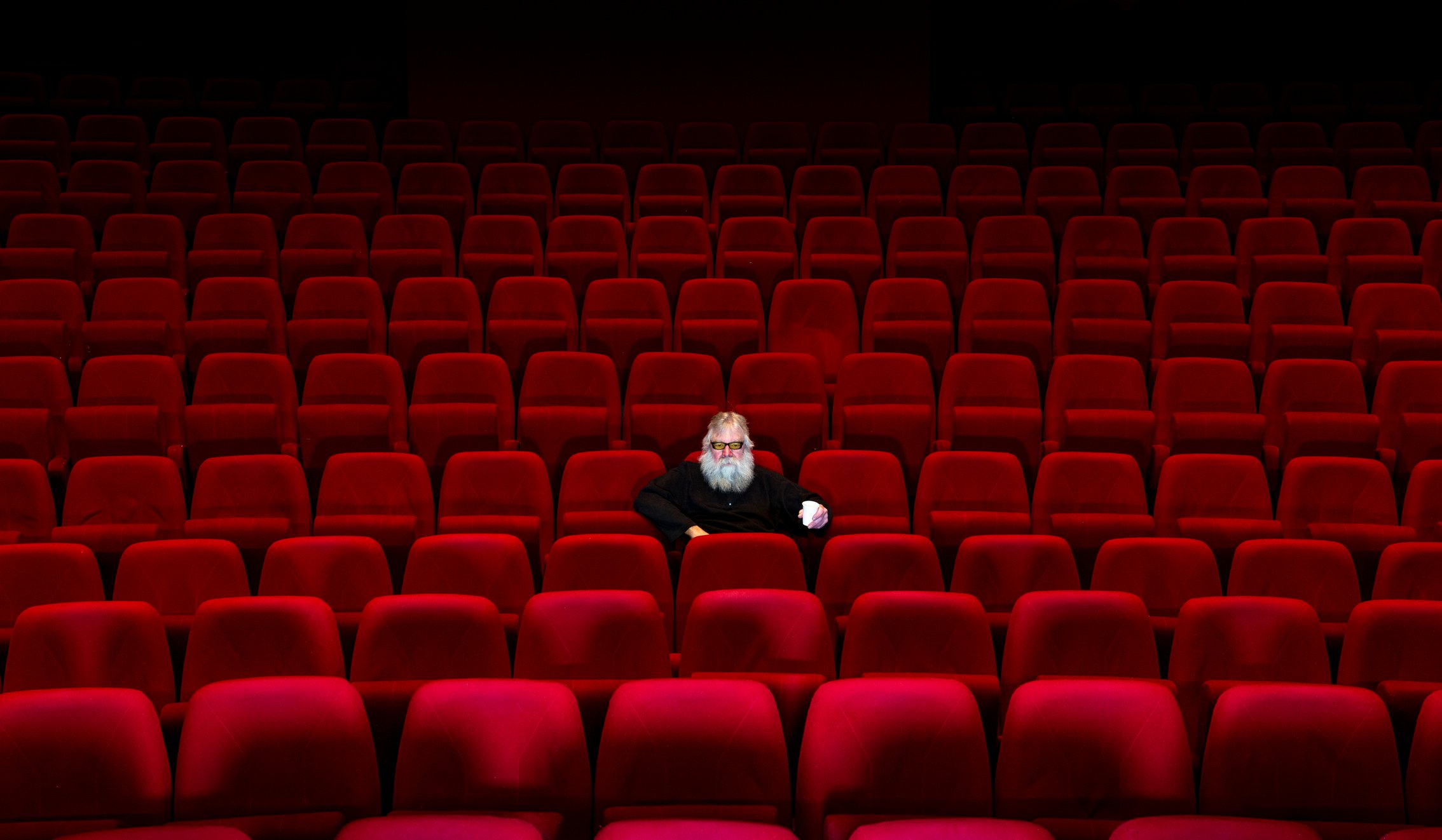 A lone person sitting in an empty movie theater.