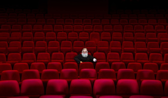 A lone person sitting in an empty movie theater.