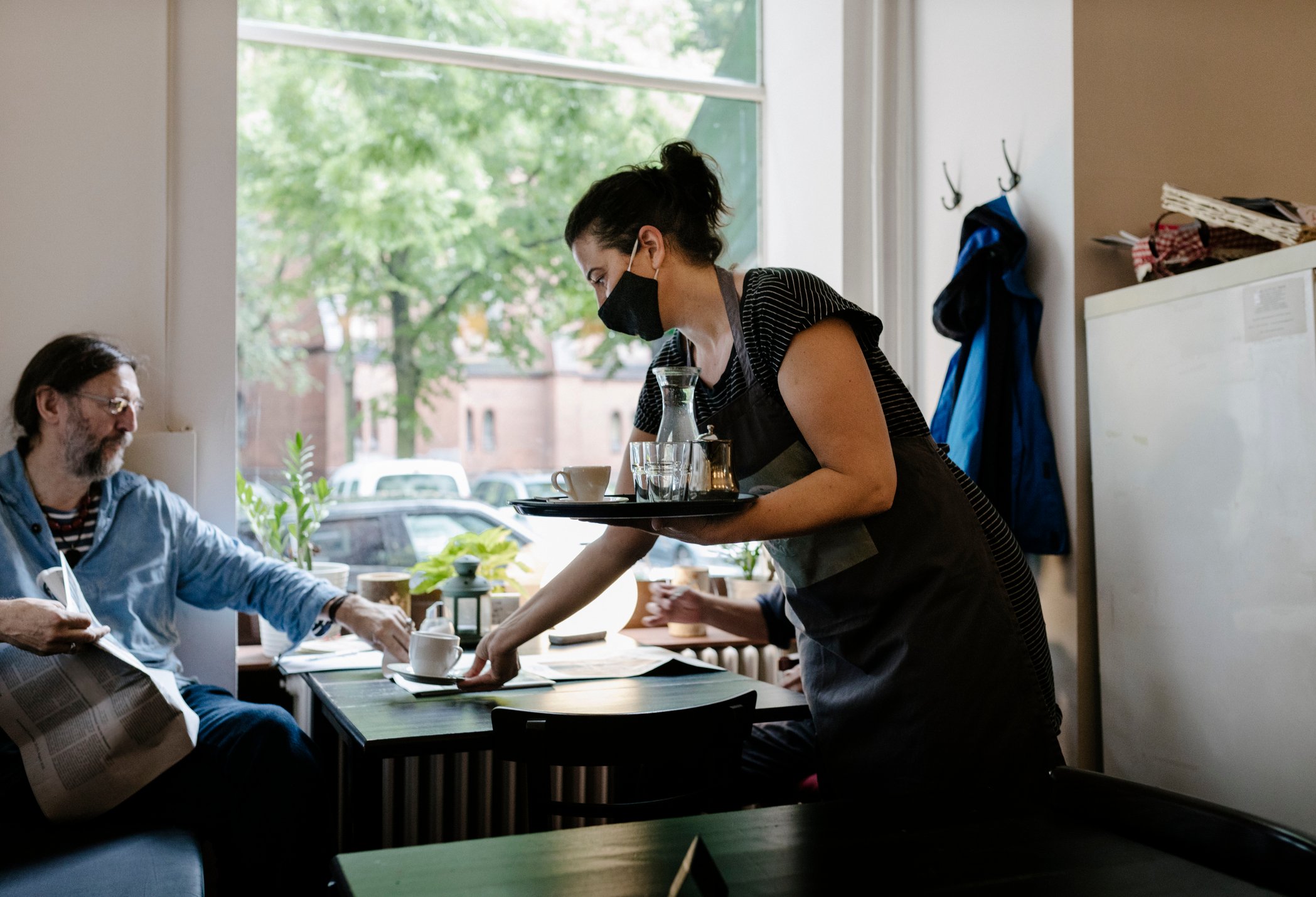 A server delivers coffee to customer at a restaurant.