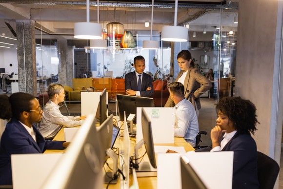 A team of people gathered around a table in an internal office.
