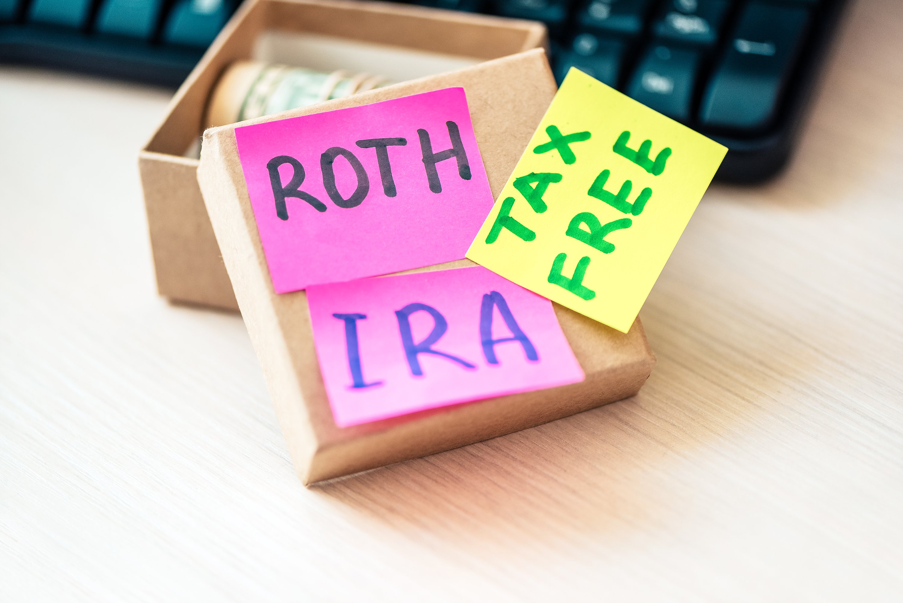 A box with a roll of cash labeled Roth IRA Tax Free.