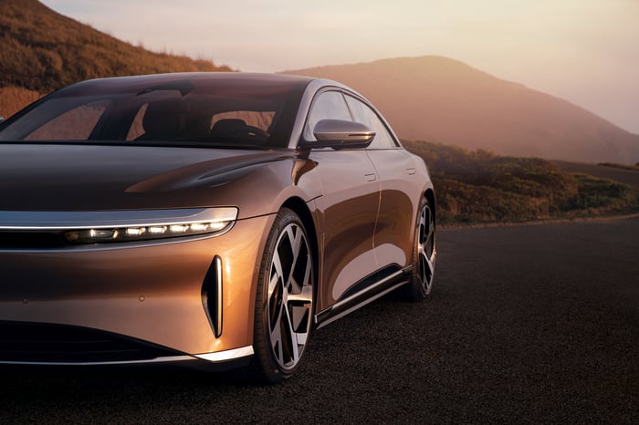 A bronze-colored Lucid Air, a sleek electric luxury-sports sedan.