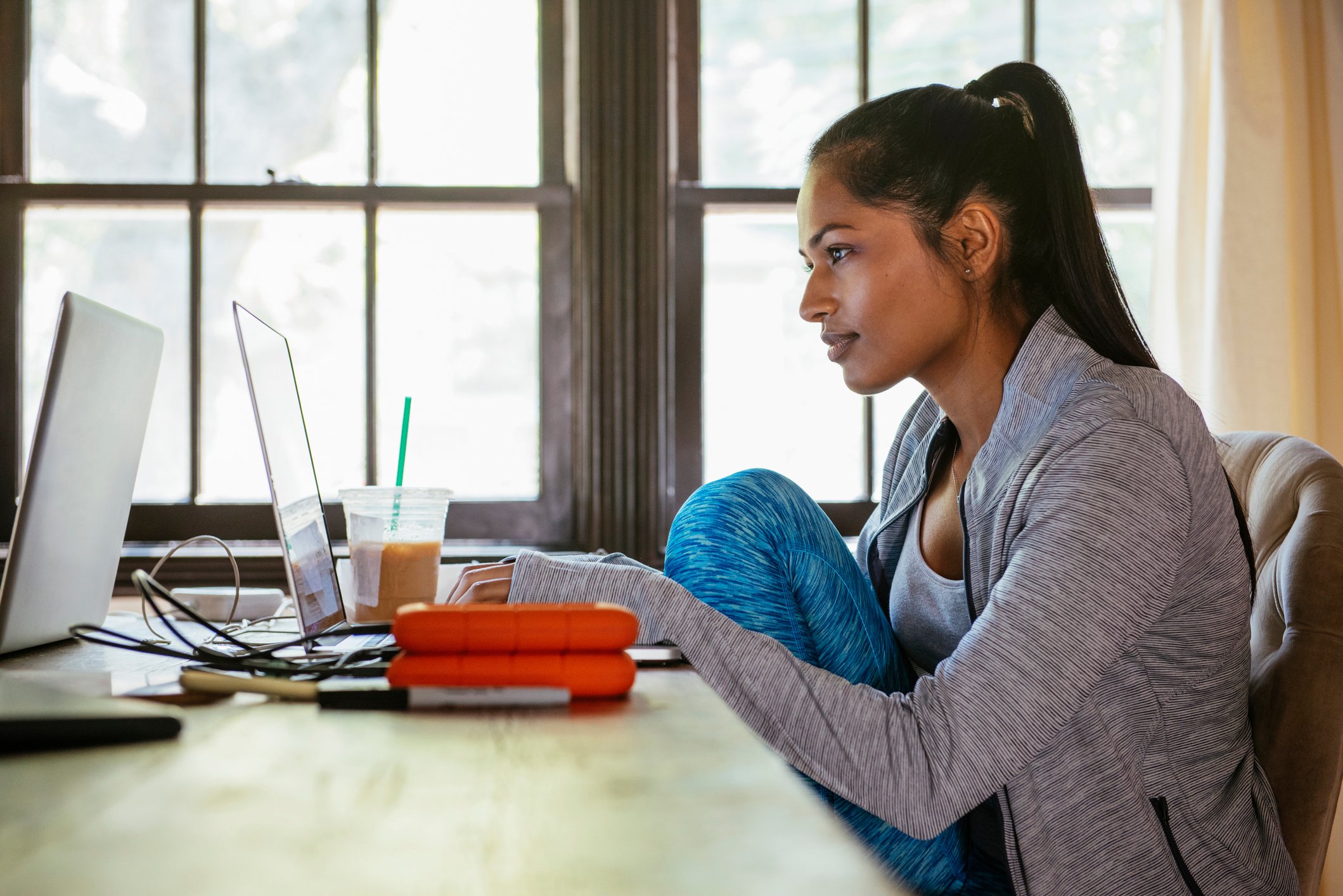 A woman wearing athletic apparel while working from home.