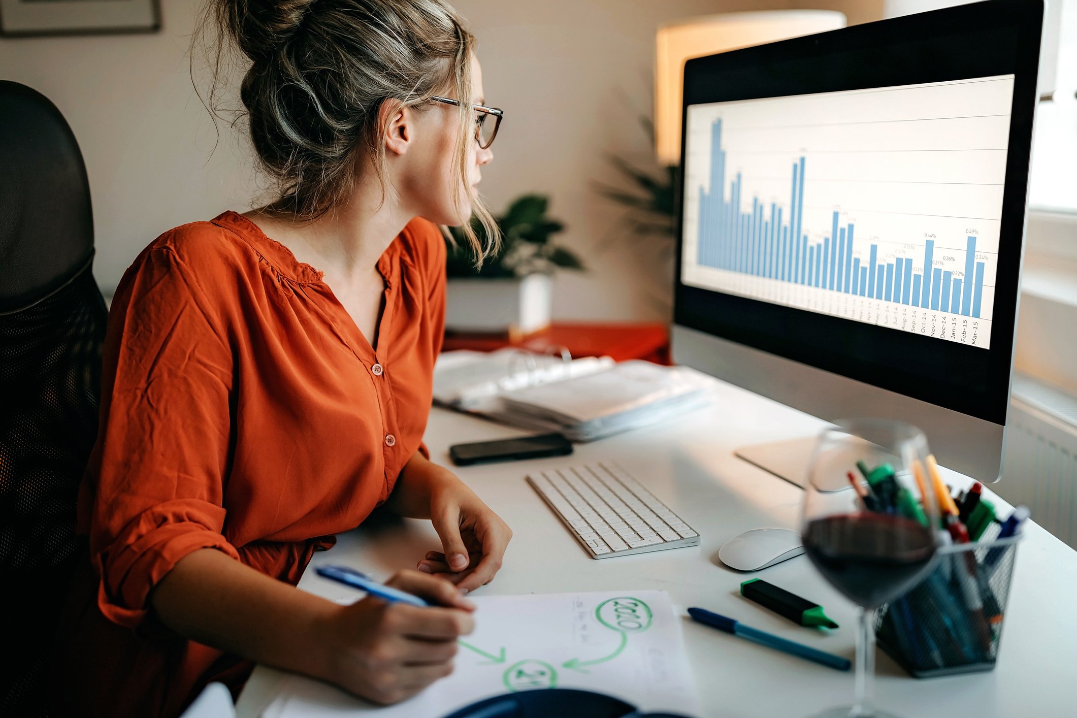 An investor studies financial charts on a computer.