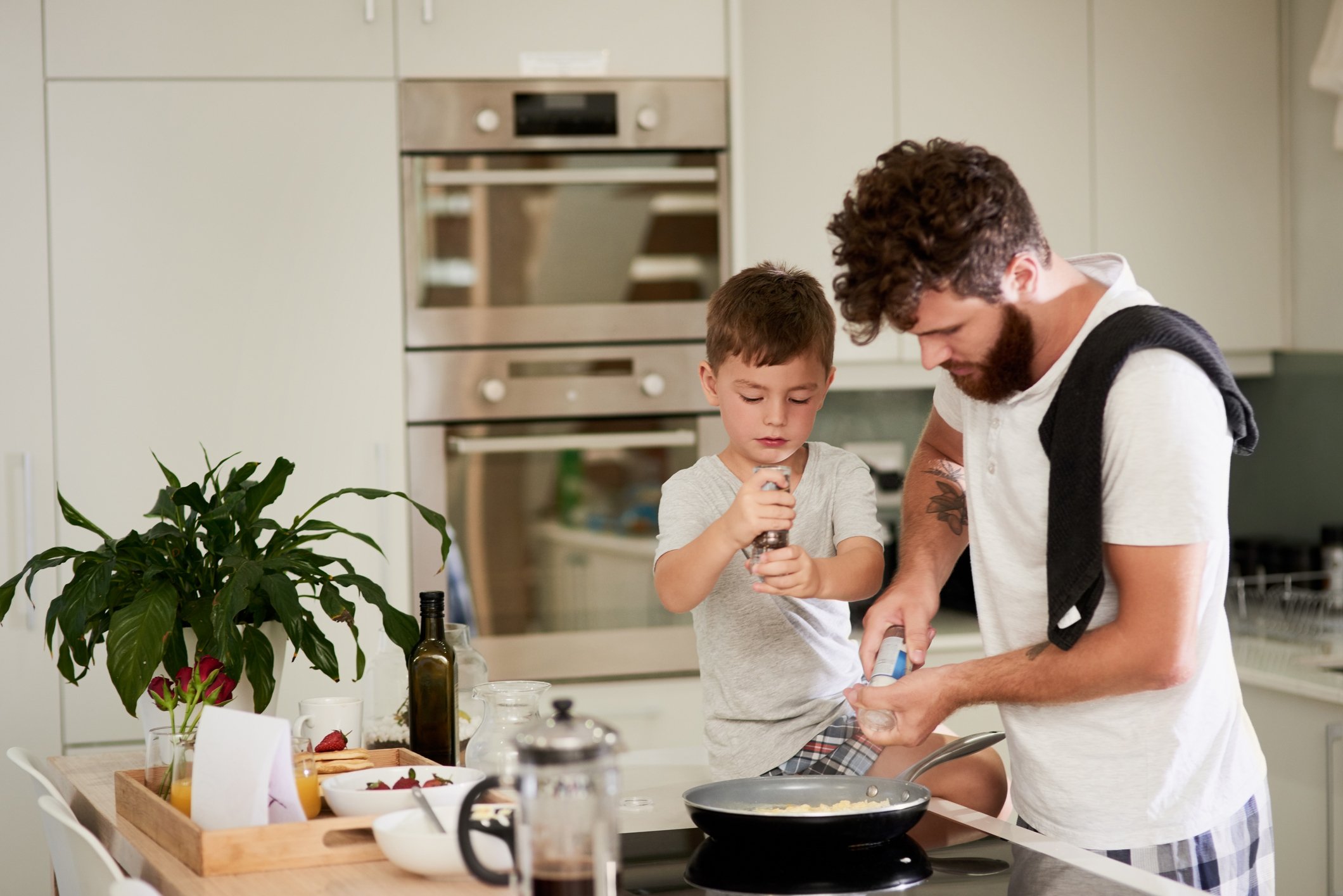 An adult and child cooking together at home.