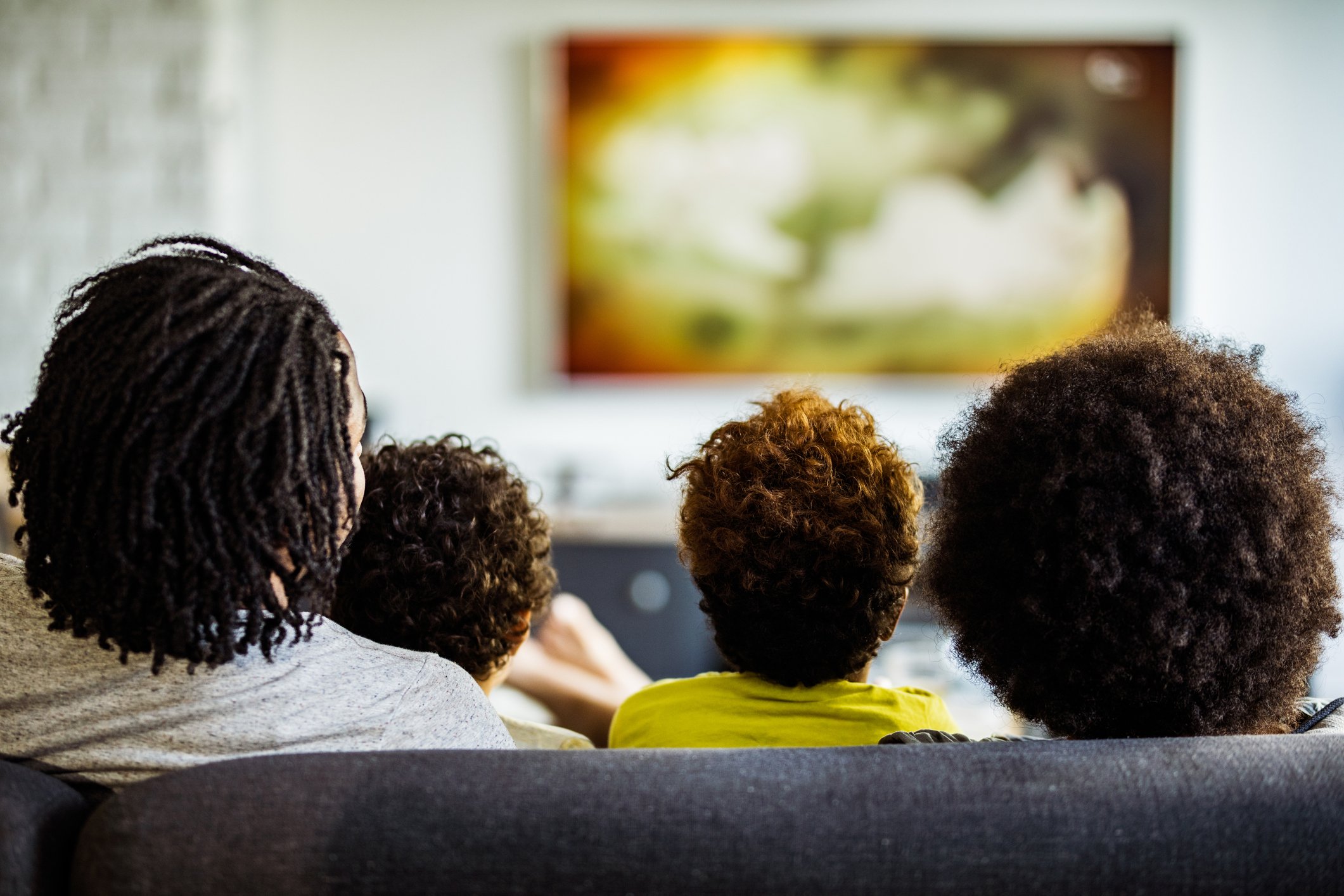 a family watches TV from a couch