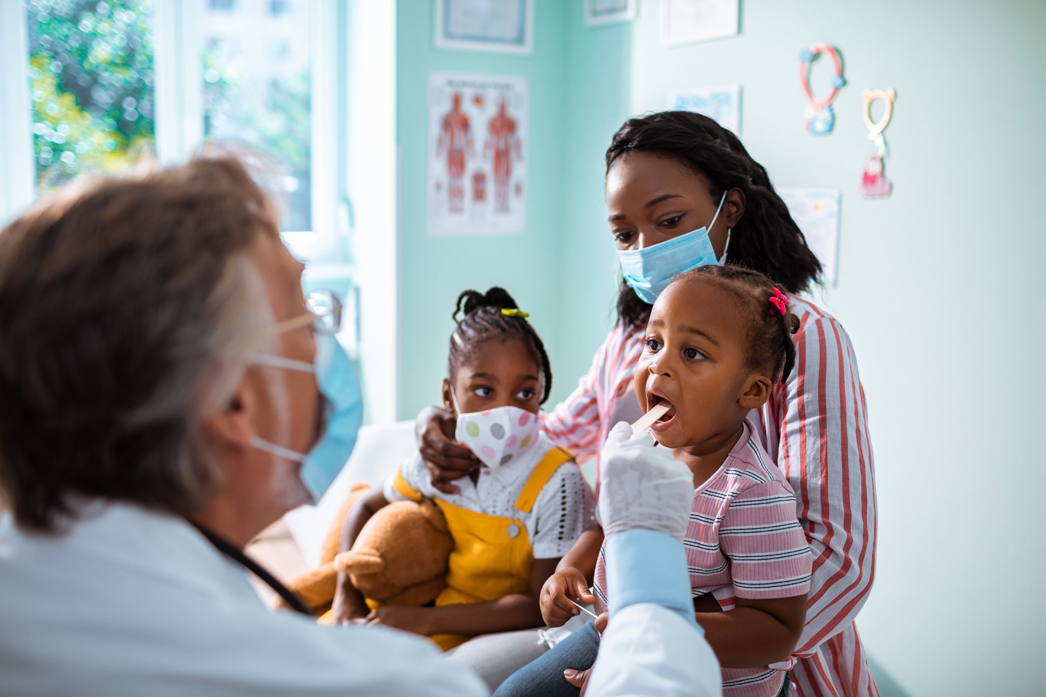 A person with two children at a physician's clinic.