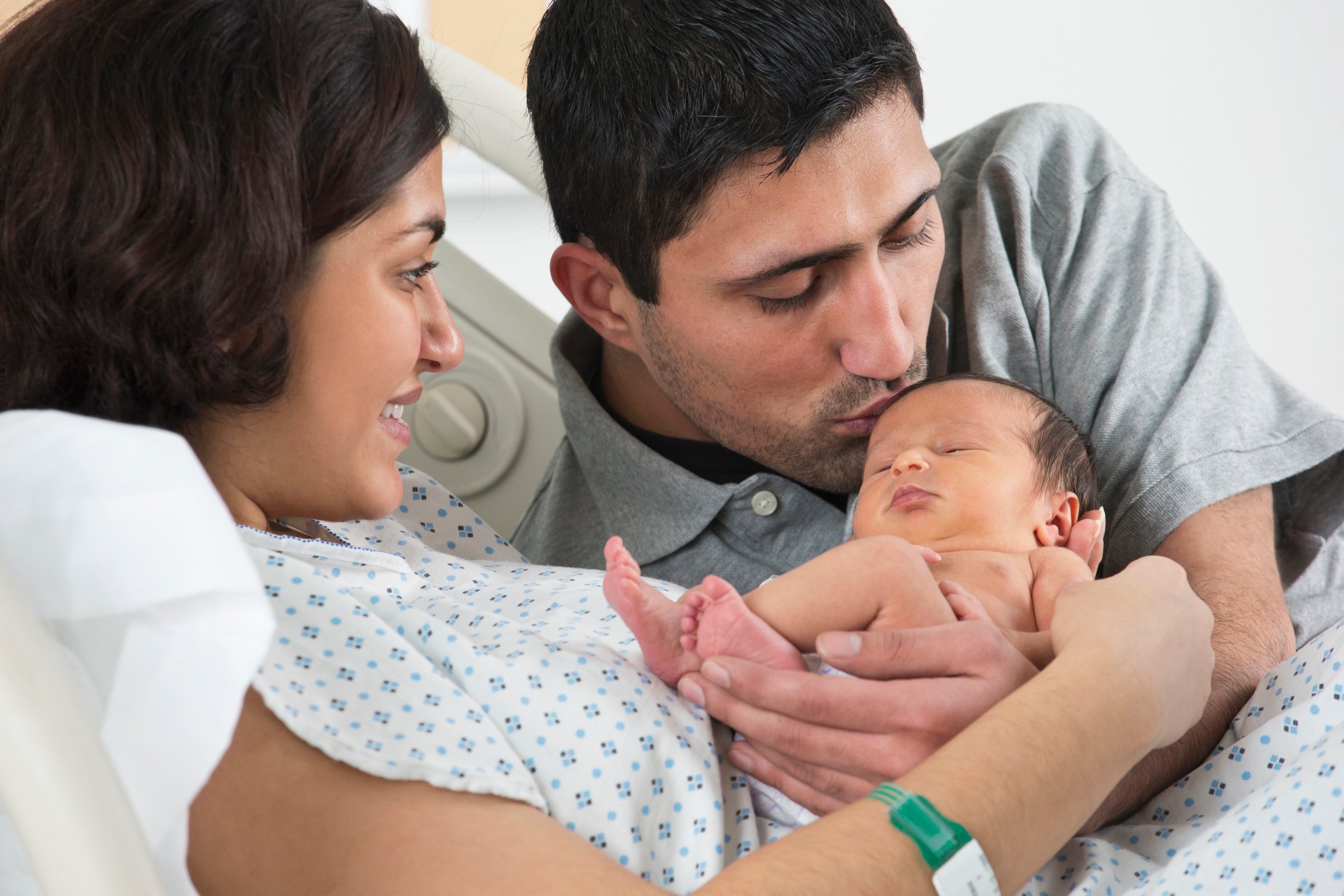 A baby being held by its parents.