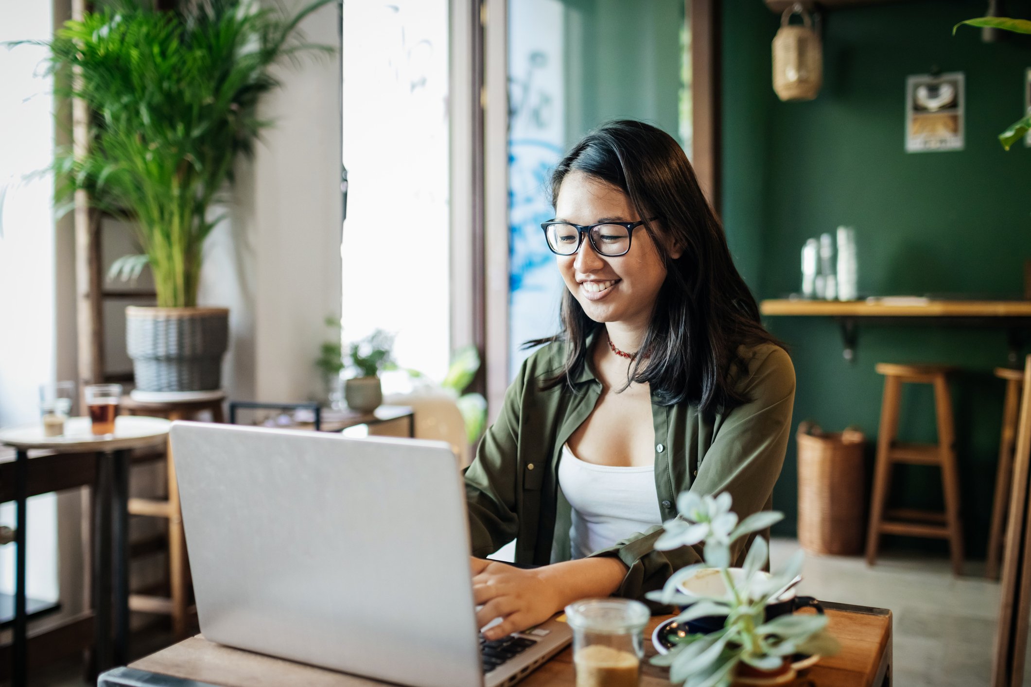 Smiling person looking at a laptop.