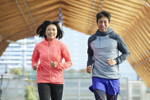 Two people jogging outside.