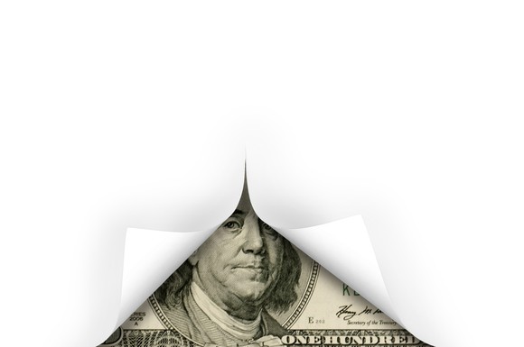 A hundred dollar bill unveiled beneath a white cover. 