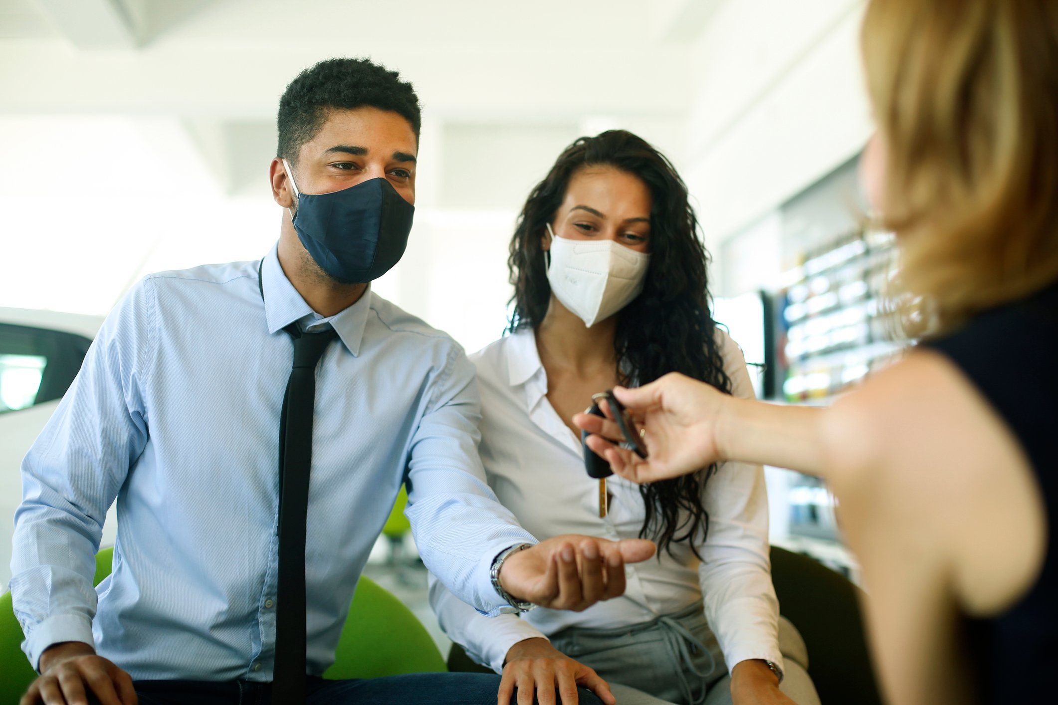 A masked couple shopping for a car during the pandemic.