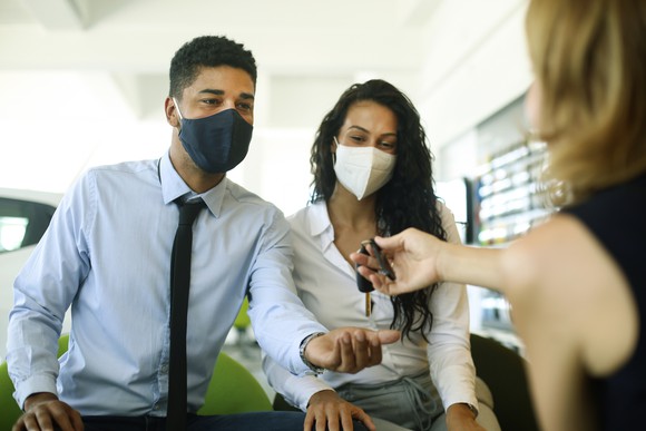 A masked couple shopping for a car during the pandemic.