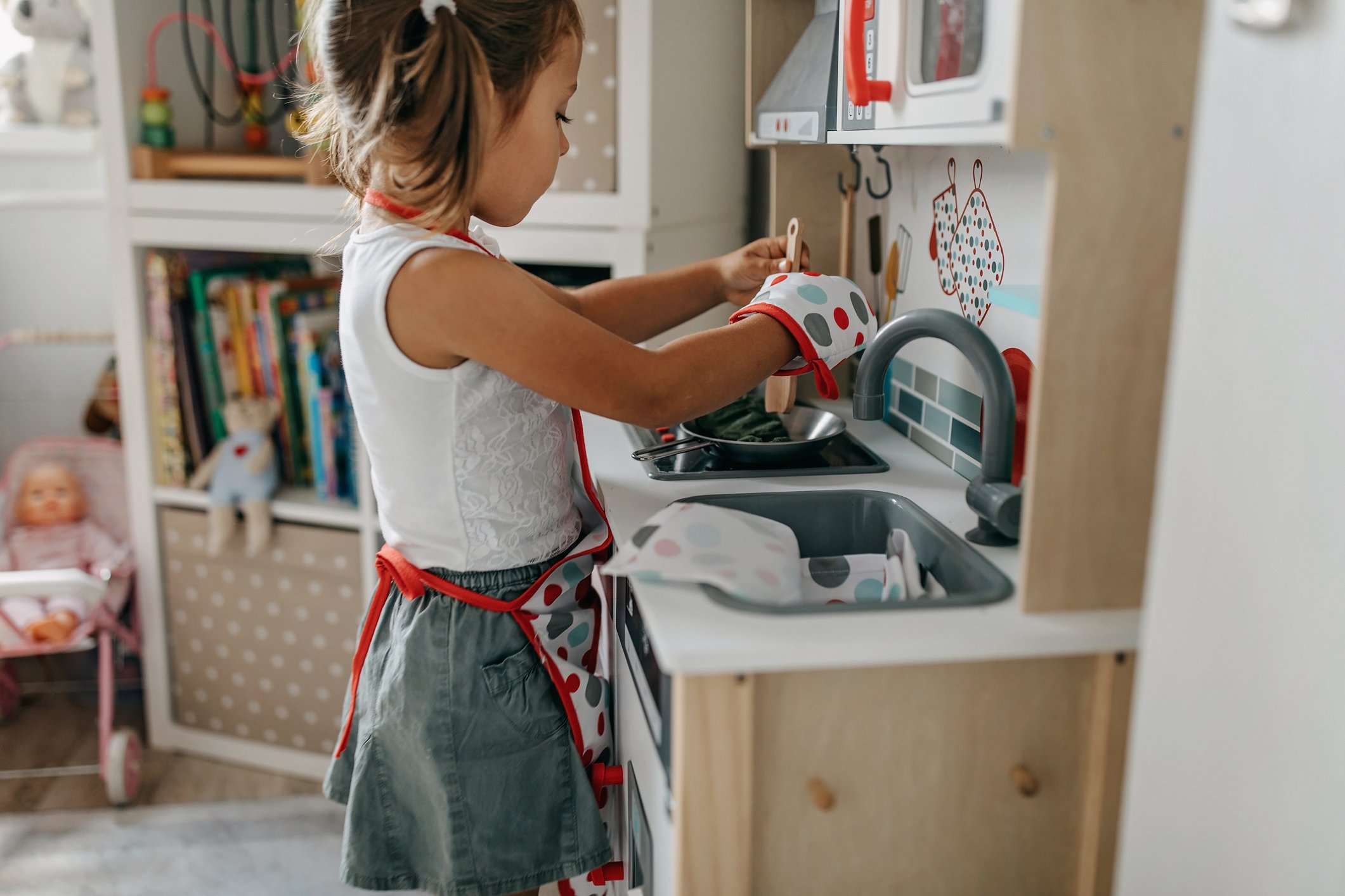 A child plays in their toy kitchen