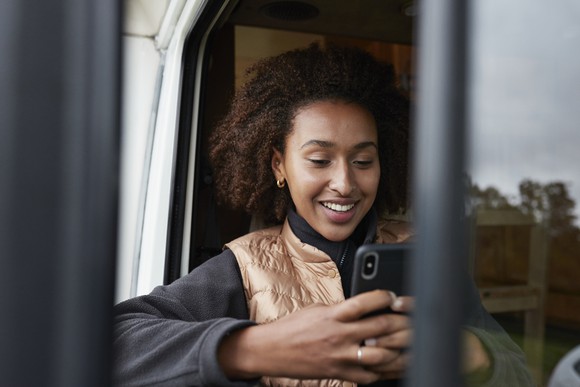 Person happily engaging with smartphone.