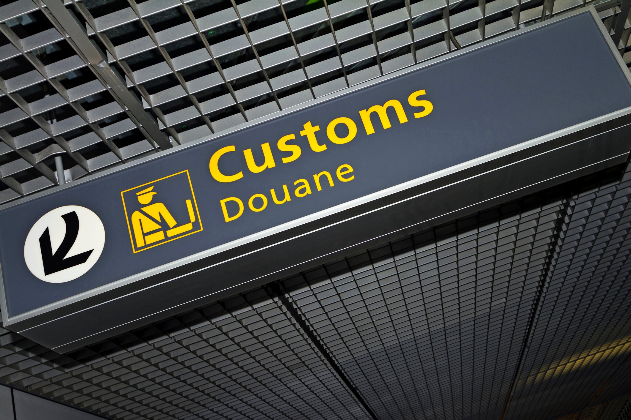 A sign directing travelers to customs in an airport.